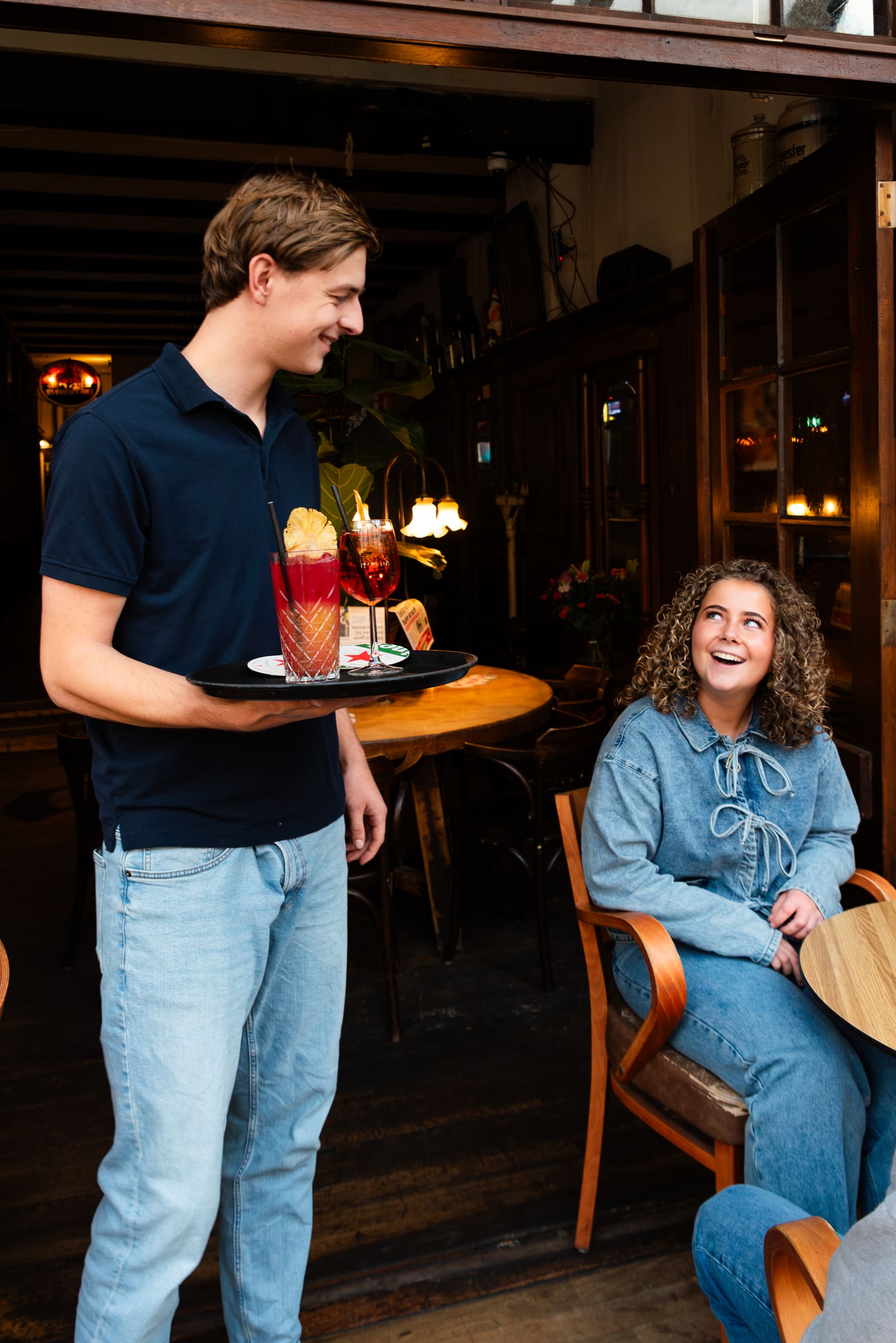 Bediening brengt cocktails naar een lachende gast