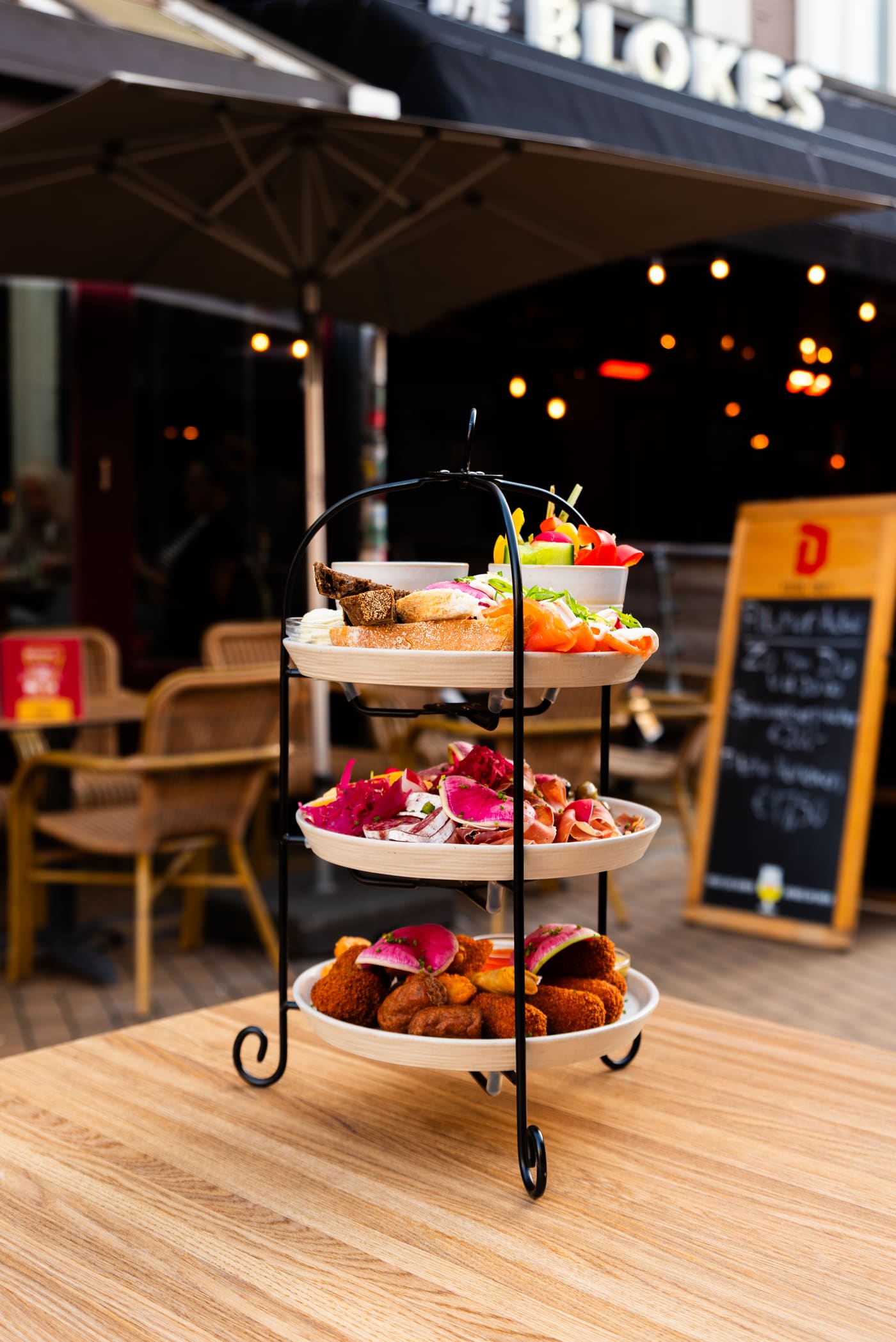Etagère met borrelhappen op het terras in de avond